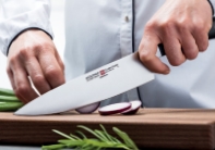 סכין שף Classic Ikon בפעולת חיתוך על קרש חיתוך